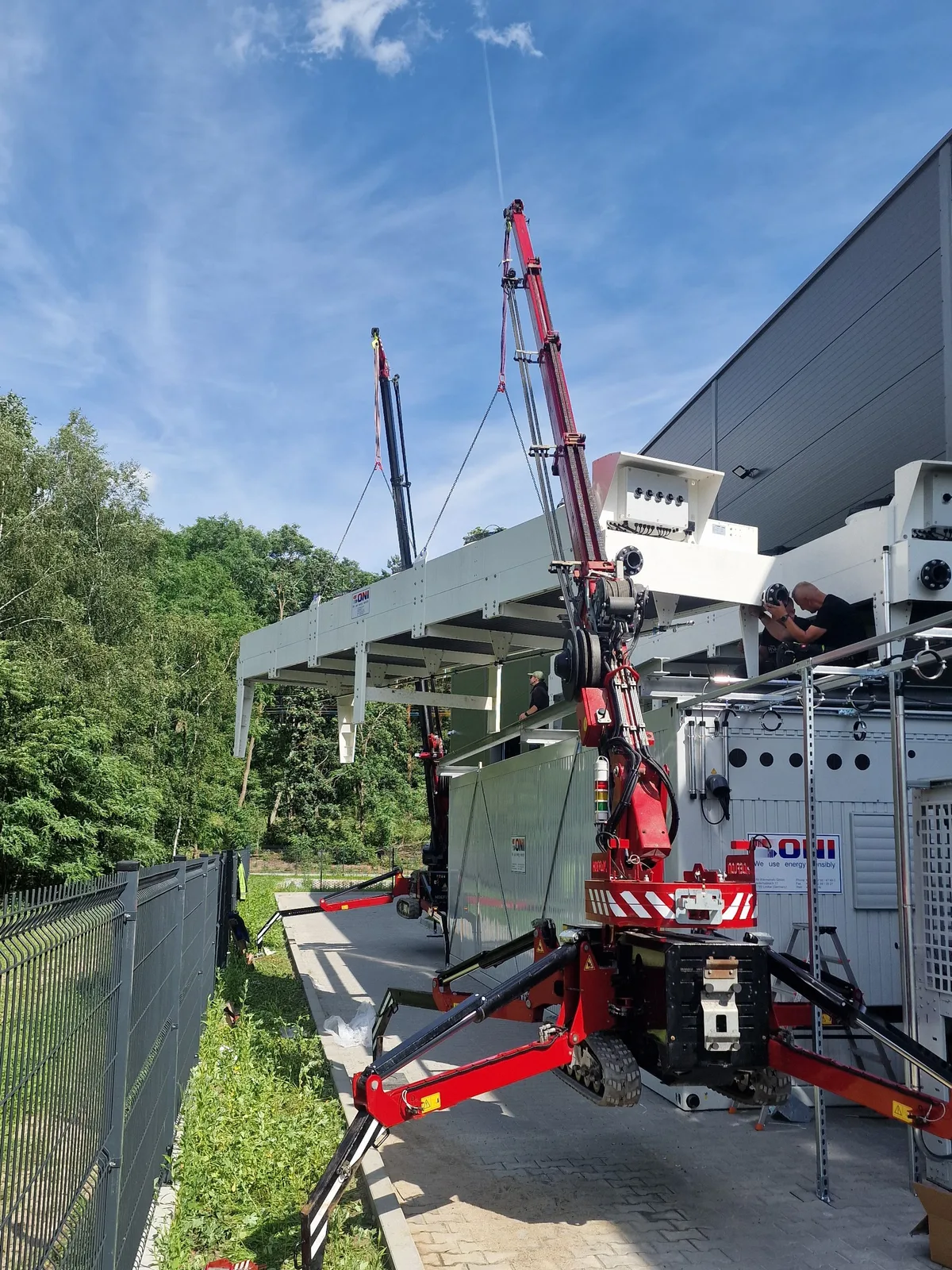 Żuraw podaje rury instalacji HVAC na dach budynku w centrum miasta